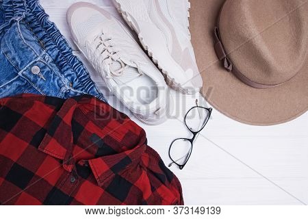 Flat Lay Composition With Red Chekered Shirt, Hat And Sneakers.