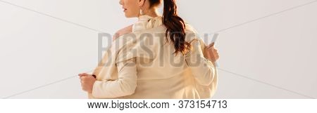 Orientation Of Brunette Businesswoman Taking Off Jacket Isolated On Grey