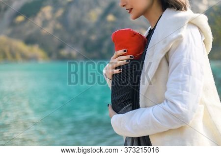 Beautiful Young Mother With Her Infant Baby In Sling Outdoor. Mother Is Carrying Her Child And Trave