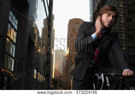 Man standing by bicycle in street talking on mobile phone low angle view