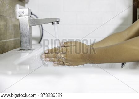 Close-up of washing hands in the sink to prevent germs. Hygiene concept and virus prevention.