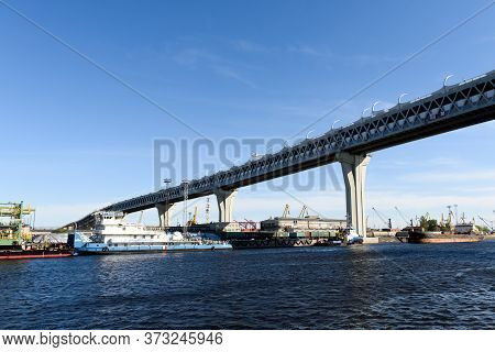 Russia, Saint Petersburg, May 30, 2020:main Road Bridge Over The Seaport. Ships And Cranes.