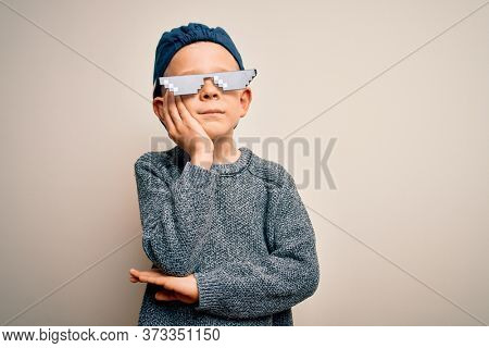 Young little caucasian kid wearing internet meme thug life glasses over isolated background thinking looking tired and bored with depression problems with crossed arms.