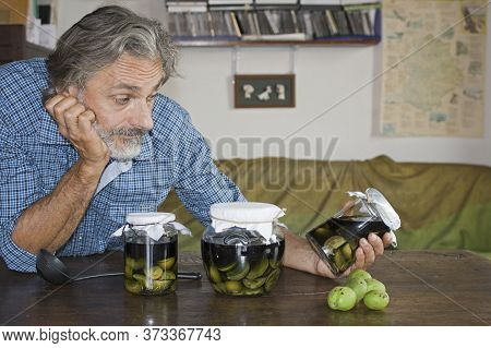 Man Posing With Nocino Jars Italian Liqueur