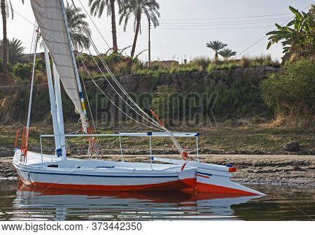 Traditional Egyptian Felluca Sailing Boat On River Nile With Reflection
