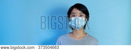 Asian Young Adult Man Wearing Face Mask With Copy Space On Isolated Turquoise Background