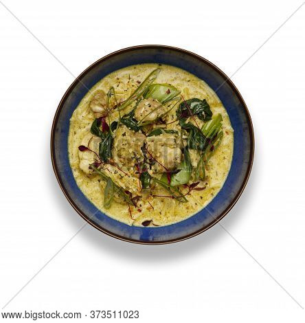 A Delicious Bowl Of  Thai Chicken Laxa Curry,  In A Rustic Blue Bowl Isolated On A White Background
