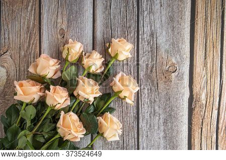 Flat View Image Of A Bouquet Of Peach Color Roses, On Brown Wooden Background