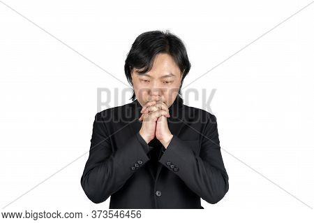 Isolated Asian Business Man In Black Suit Hand Together And Prays For Something On White Background.