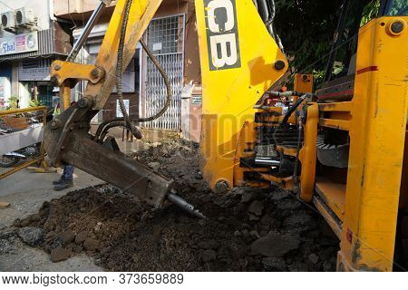 Jcb Earth Moving Machine Working On A Road. Jcb Bucket Loader Is Repairing A Section Of A Dirt Road.