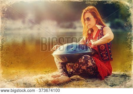 Beautiful Woman Playing With Hangdrum In Nature. Old Photo Effect.