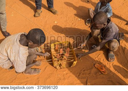 Bissau, Guinea-Bissau - January 5, 2020: group of African Kids playing with a made toy, in rural Guinea-Bissau