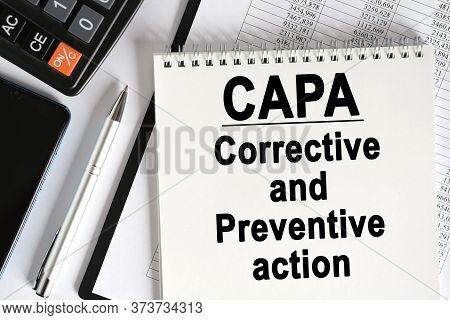 On The Table Lies A Smartphone, A Calculator And A Notebook With The Inscription- Capa. Corrective A
