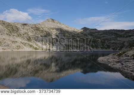 The View Of Mountain Reflection In Lago Della Vacca, Lombardy, Italy.