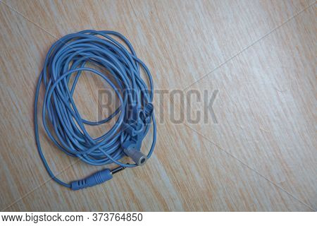 Audio Mini Jack Cable For Microphone Isolated On Wooden Background . Blue Microphone And Headphone S
