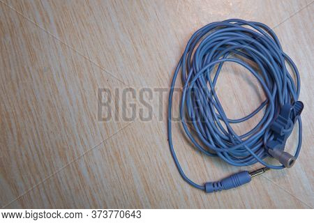 Audio Mini Jack Cable For Microphone Isolated On Wooden Background . Blue Microphone And Headphone S