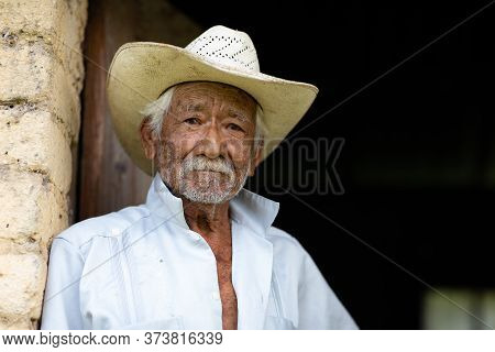 El Chorrito, Tamaulipas, Mexico, July 2, 2019: Mexican Senior, At His Adobe Home, Waits By His Door