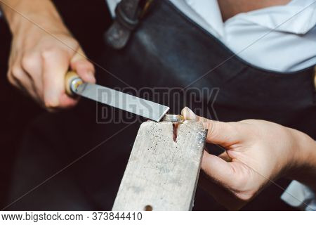 Closeup of jewelry designer working with file on a ring to smoothen it