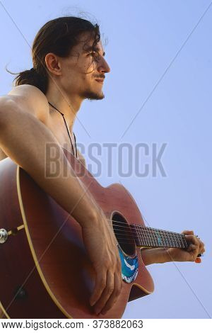 Guitarman Plays On Guitar In Front Of The Sky