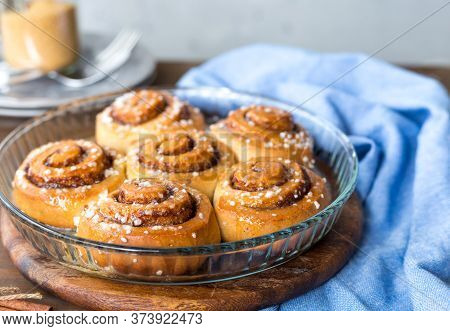Freshly Baked Cinnamon Buns With On A Wooden Background. Kanelbule - Swedish Dessert. Food Concept.