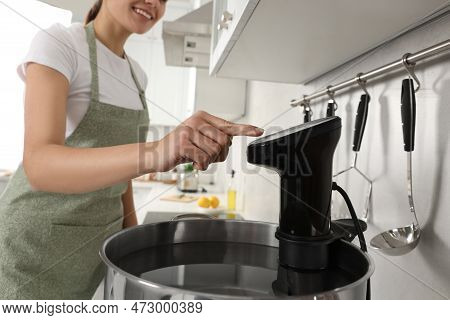 Woman Using Thermal Immersion Circulator In Kitchen, Closeup. Sous Vide Cooking