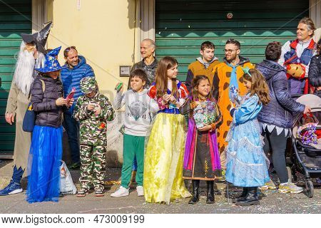 Cantu, Italy - February 25, 2023: Spectators In Costumes Attend The Carnival Parade, In Cantu, Lomba