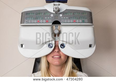 Cliente di un oculista o ottico guardando attraverso forottero