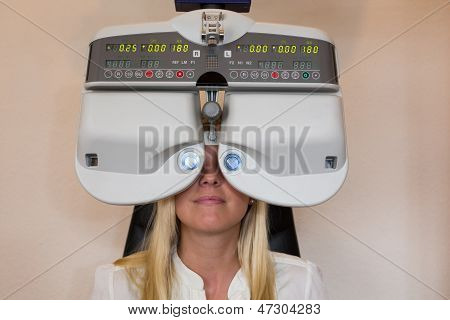 Cliente di un oculista o ottico guardando attraverso forottero