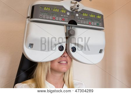 Cliente di un oculista o ottico guardando attraverso forottero