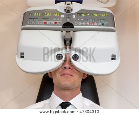 Cliente di un oculista o ottico guardando attraverso forottero