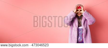 Fashion And Shopping. Happy Asian Grandmother In Stylish Faur Fur Coat, Looking Through Hand Glasses