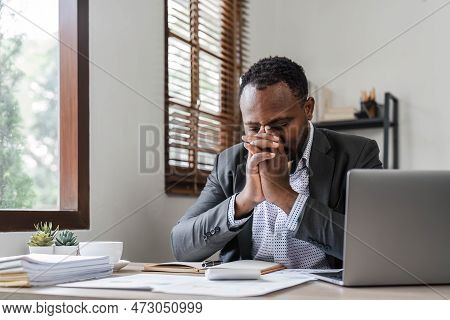 Stressed Business Man Sitting At Office Workplace. Tired And Overworked Black Man. Young African Ame