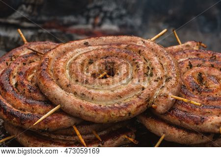 Pork Meat Skewer, Grilled Or Roasted In A Barbecue With Pitchforks On An Open Fire And Flames, Shash