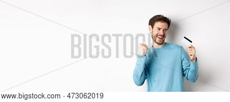 Happy Man Dancing With Plastic Credit Card, Smiling And Saying Yes, Celebrating On White Background