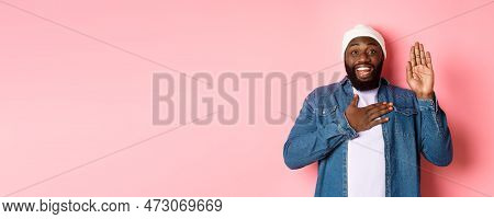 Image Of Smiling African-american Man Being Honest, Telling Truth, Hands On Heart And In Air, Making