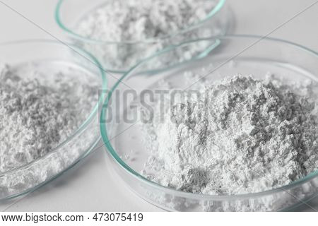 Petri Dishes With Calcium Carbonate Powder On White Table, Closeup