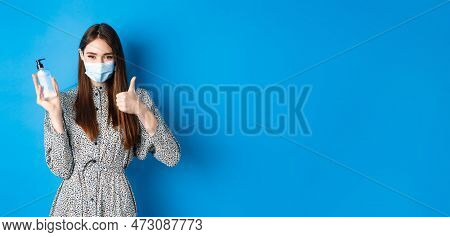 Covid-19, Social Distancing And Healthcare Concept. Beautiful Girl In Medical Mask Using Hand Sanizi