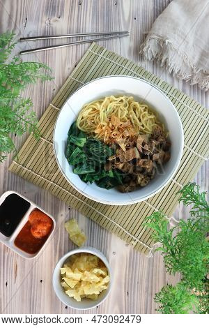 Noodles Topped With Chicken And Vegetables On A White Bowl