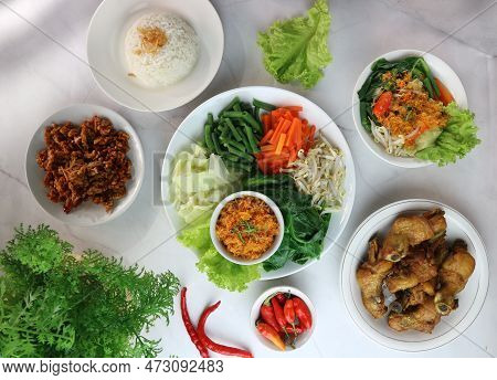 A Variety Of Indonesian Traditional Food Served On White Plates