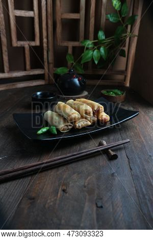 Fried Spring Rolls With Soy Sauce On Black Plate On Wooden Background