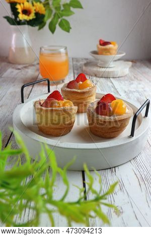 Tartlets With Fresh Berries And Orange Juice On A Wooden Background