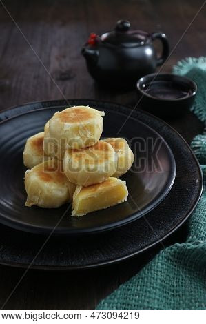 Sweet And Delicious Peanut Cake On Black Plate And Tea Pot On Wooden Table