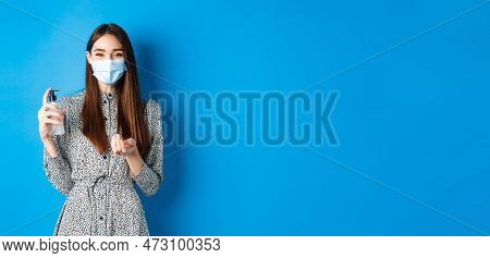 Covid-19, Social Distancing And Healthcare Concept. Beautiful Girl In Medical Mask Using Hand Sanizi