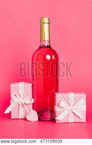 Bottle Of Wine On Colored Background For Valentine Day With Gift Box. Heart Shaped With Presrnt Box 