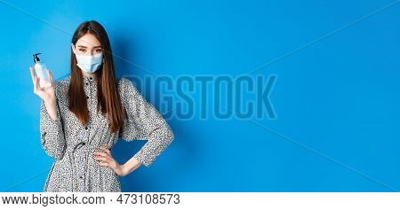 Covid-19, Social Distancing And Healthcare Concept. Beautiful Girl In Medical Mask Using Hand Sanizi