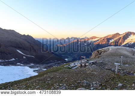 Mountain Panorama View With Flag Seen From Grosser Burgstall During Sunrise In Glockner Group, Austr