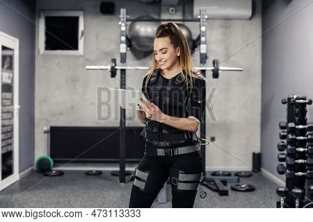 Ems Training Concept. Electrical Muscle Stimulation. A Satisfied Young Female In A Special Ems Suit 