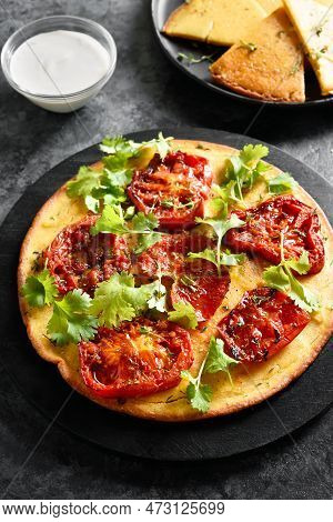 Healthy Pizza (vegan And Gluten-free) Made From Chickpea Flour With Tomato On Wooden Boadr Over Dark