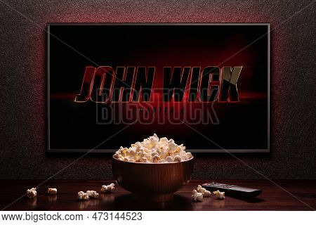 Tv Screen Playing John Wick Chapter 4 Trailer Or Movie. Tv With Remote Control And Popcorn Bowl. Mos