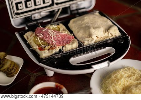 Cooking Waffles Stuffed With Sausage, Cheese. Pizza Waffle, Piffle. Open Waffle Iron With Yeast Doug